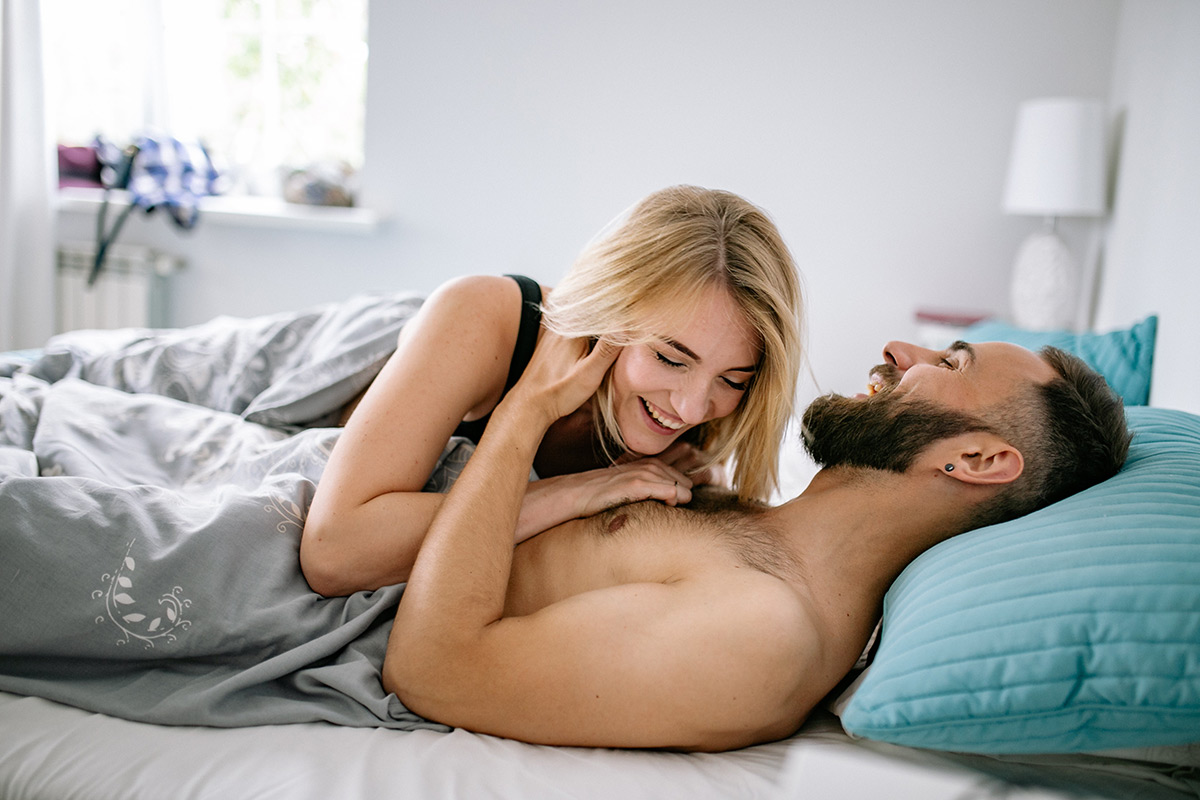 a couple having fun in bed to help boost their libido